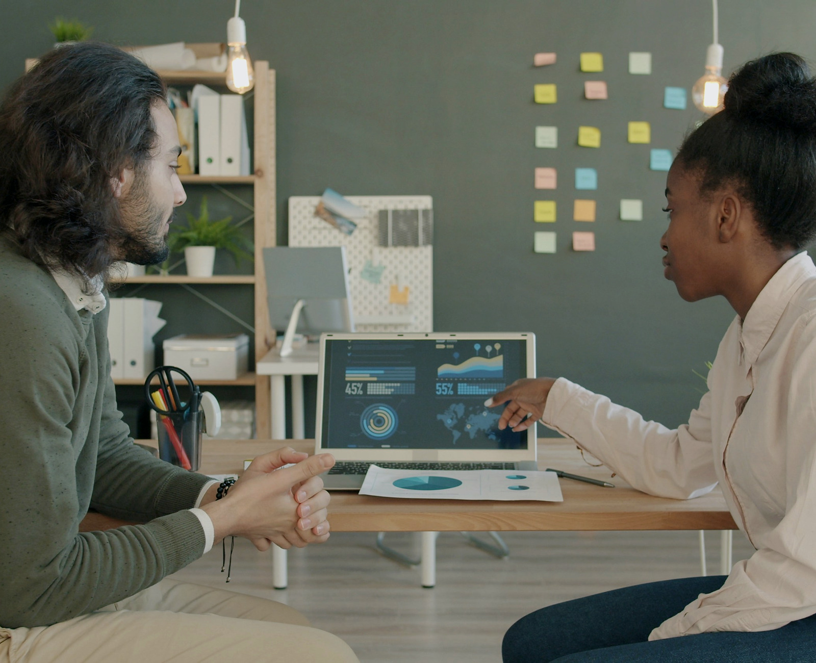 Two professionals reviewing dashboard data together in a modern office.